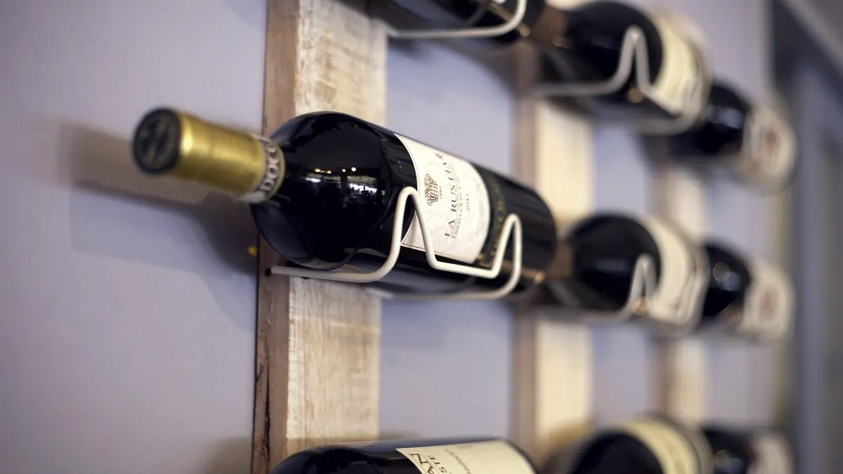 Garrafas de vinho deitadas em um suporte de parede